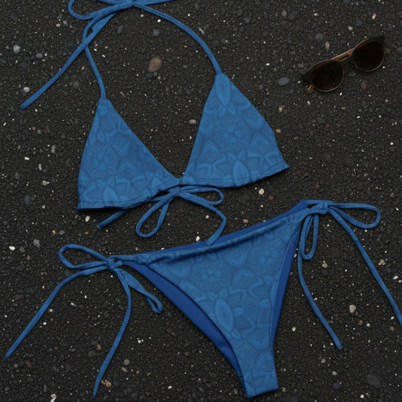 blue bikini laying on black sand beach