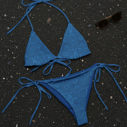 blue bikini laying on black sand beach