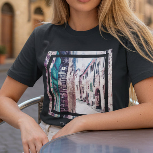 Tuscan Stone Alley Art Tee by Gena Sage Studios in India Ink Grey featuring textured Italian village street with rustic stone buildings and abstract frame overlay